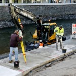 Foto: Ein Vermessungstechniker prüft die Lagegenauigkeit der neuen Uferplatten.