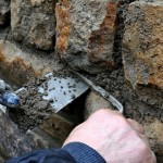 Foto: Echte Handarbeit - Stein um Stein wird der Mörtel an der Bruchsteinmauer mit der Kelle verfüllt.